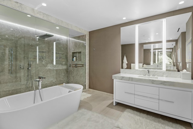 full bath featuring a freestanding bath, baseboards, recessed lighting, a shower with door, and vanity