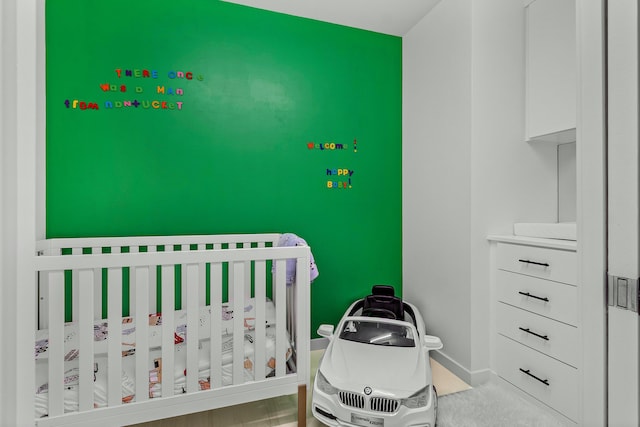bedroom with a nursery area and baseboards