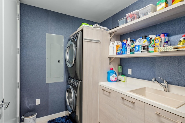 washroom featuring electric panel, a sink, stacked washer / drying machine, a textured wall, and laundry area