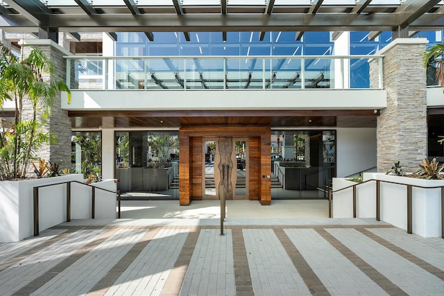 property entrance featuring a pergola and a balcony