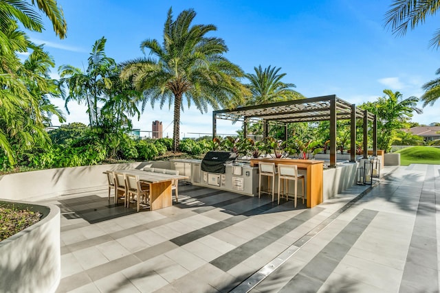 view of patio with an outdoor kitchen, a grill, a bar, and a pergola