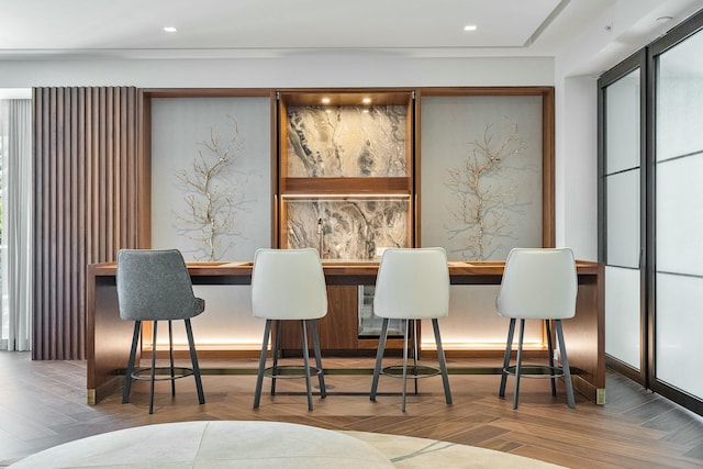 dining space featuring parquet floors and bar