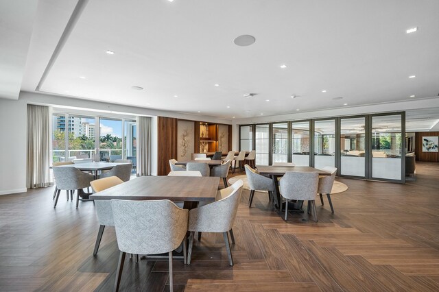 kitchen with dark parquet flooring, white cabinets, light stone countertops, and pendant lighting