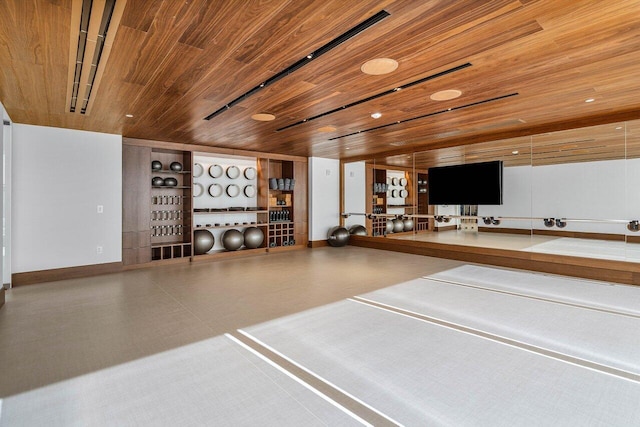 exercise room featuring baseboards, tile patterned floors, and wooden ceiling