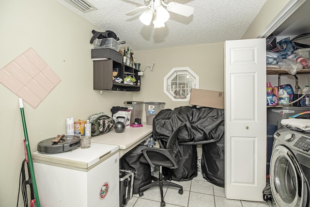 office space with a textured ceiling, washer / clothes dryer, ceiling fan, and light tile patterned flooring