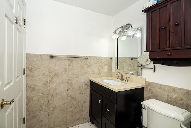 bathroom with tile patterned floors, vanity, toilet, and tile walls