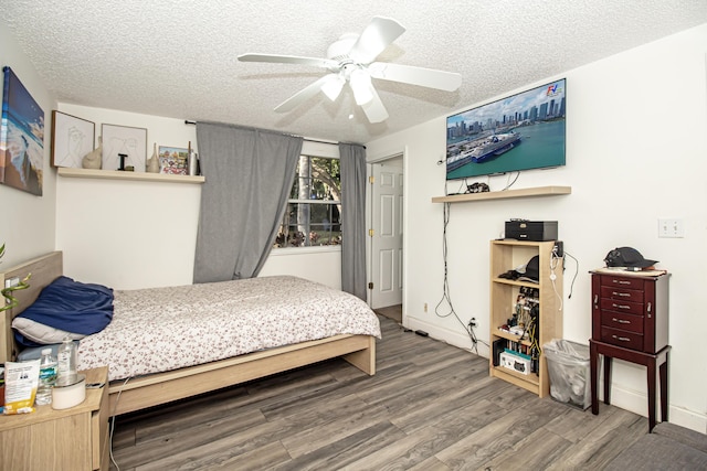 bedroom with ceiling fan, hardwood / wood-style floors, and a textured ceiling