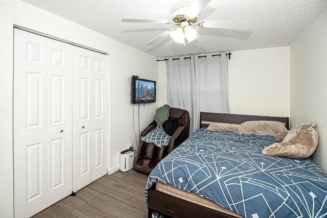 bedroom with hardwood / wood-style floors, a textured ceiling, a closet, and ceiling fan