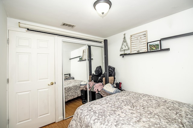 bedroom with hardwood / wood-style floors and a closet