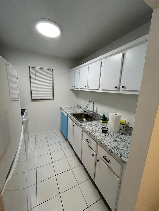 kitchen with light stone countertops, sink, white cabinets, stainless steel dishwasher, and light tile patterned flooring