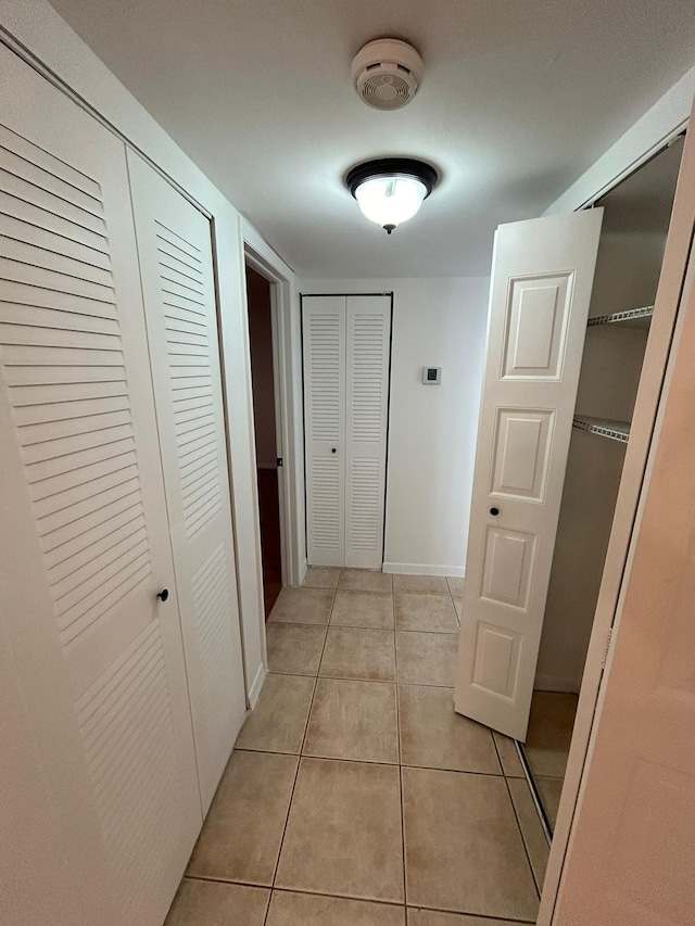 hall featuring light tile patterned floors