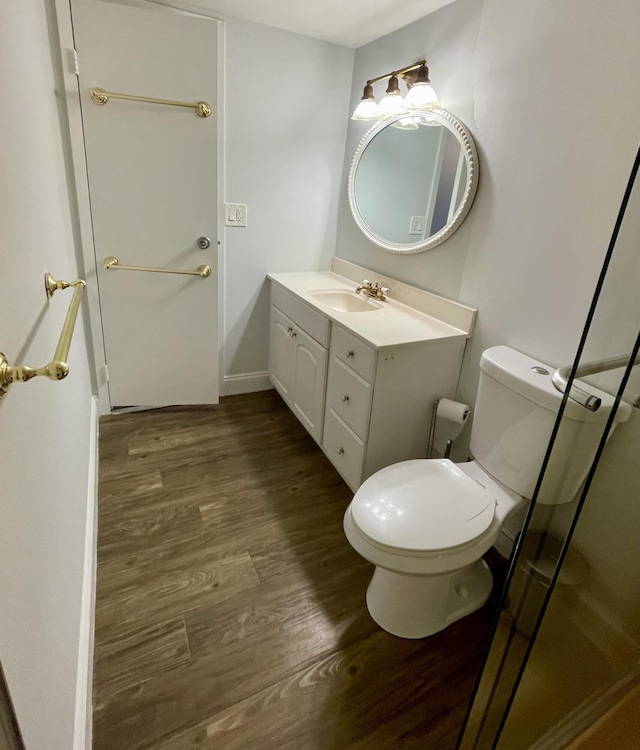 bathroom with toilet, vanity, and hardwood / wood-style flooring