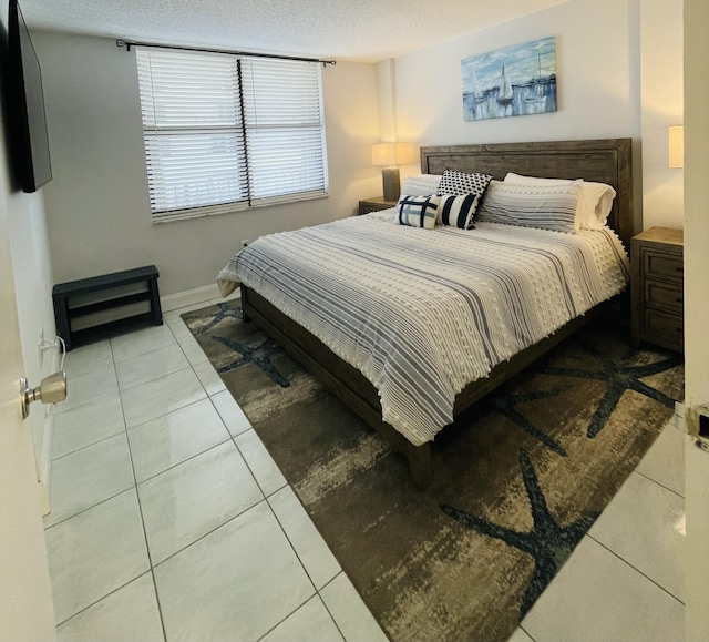 bedroom with light tile patterned floors and a textured ceiling