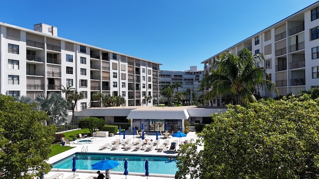 view of pool with a hot tub and a patio area