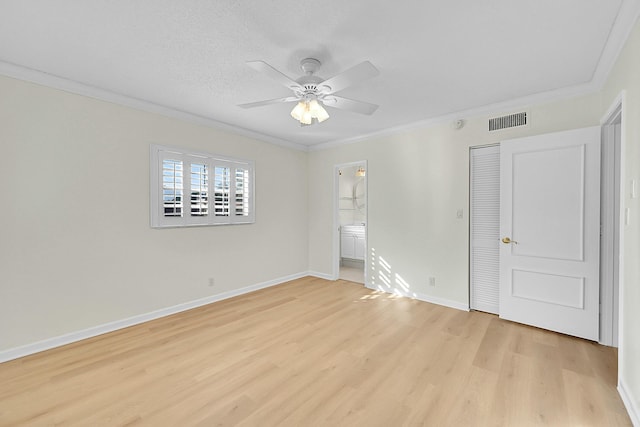 empty room featuring a textured ceiling, ceiling fan, light hardwood / wood-style floors, and crown molding