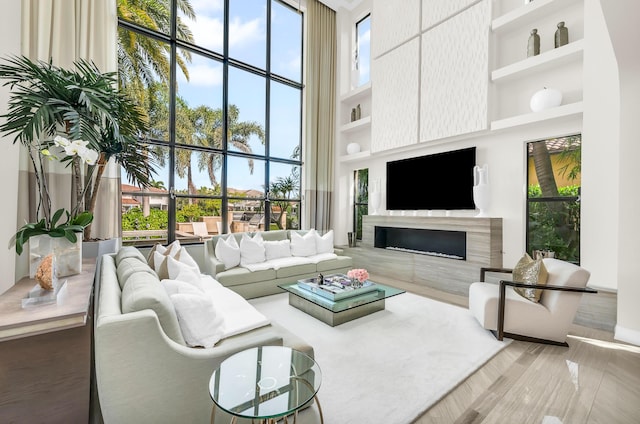 living room with a towering ceiling and hardwood / wood-style flooring