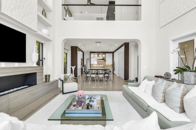 living room with a towering ceiling and a chandelier