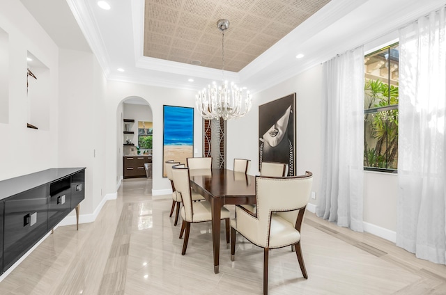 bedroom with a raised ceiling, ensuite bath, carpet flooring, and a notable chandelier