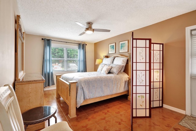 bedroom with ceiling fan and a textured ceiling