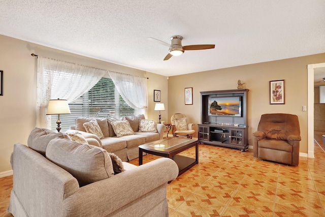 living room featuring ceiling fan and a textured ceiling