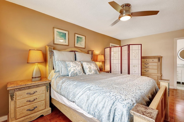 bedroom with a textured ceiling, dark tile patterned floors, and ceiling fan