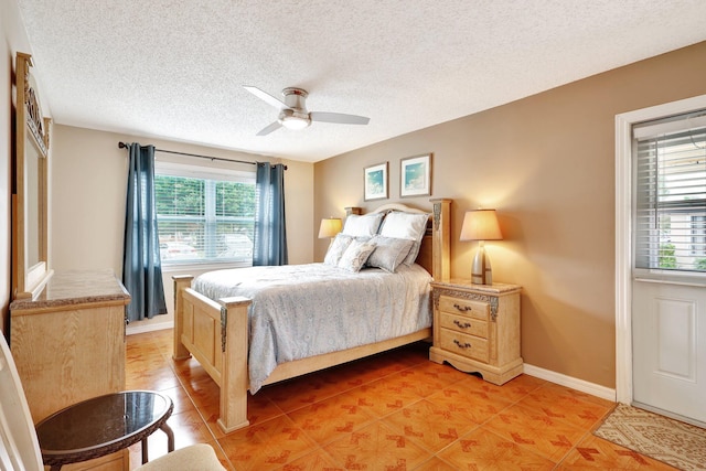 bedroom featuring tile patterned floors, ceiling fan, and a textured ceiling