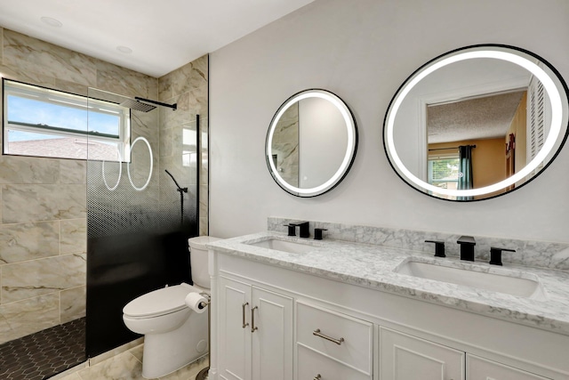 bathroom featuring toilet, vanity, and tiled shower