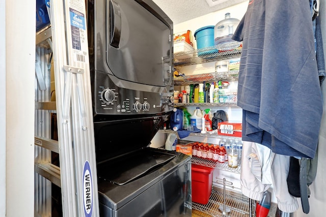 kitchen featuring a textured ceiling and stacked washer and clothes dryer