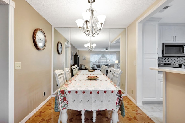 dining room with a notable chandelier, light tile patterned floors, and a textured ceiling