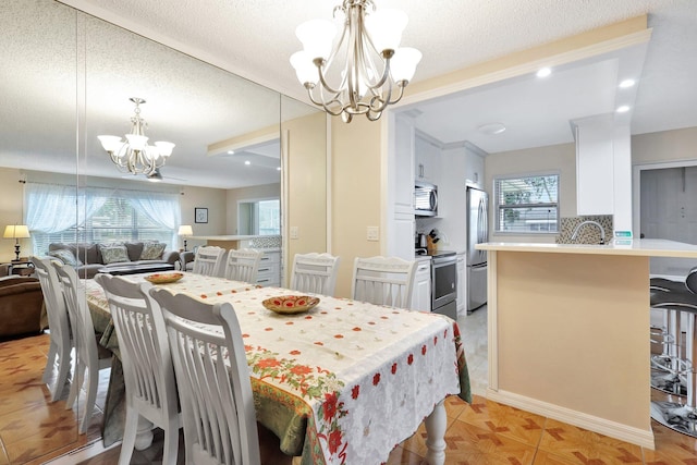 dining space with a textured ceiling and an inviting chandelier