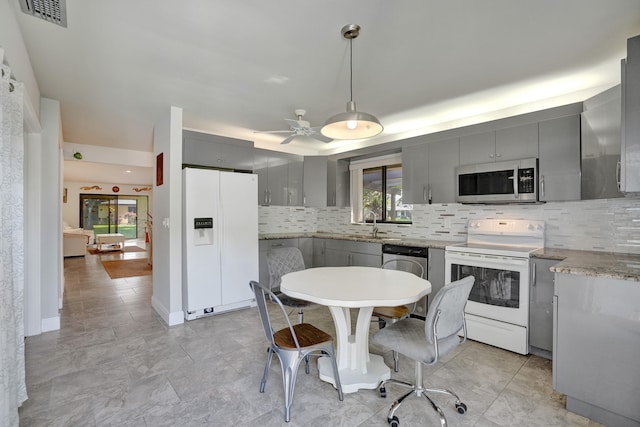 kitchen with gray cabinetry, stainless steel appliances, ceiling fan, pendant lighting, and backsplash