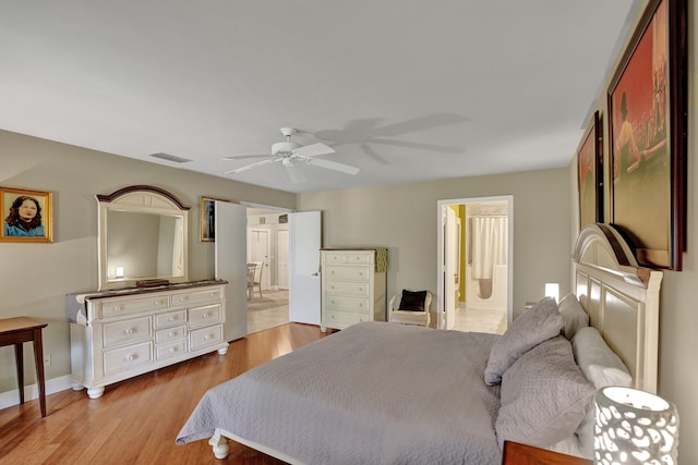 bedroom featuring ceiling fan, light wood-type flooring, and ensuite bath