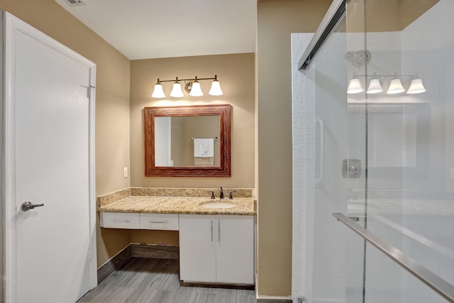 bathroom with walk in shower, vanity, and hardwood / wood-style flooring