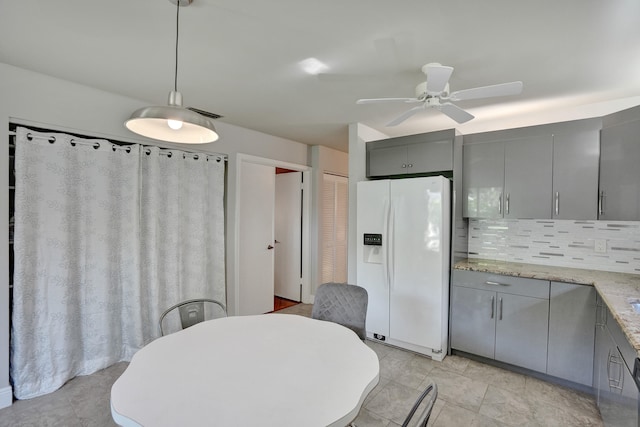 kitchen with white refrigerator with ice dispenser, tasteful backsplash, gray cabinetry, and pendant lighting