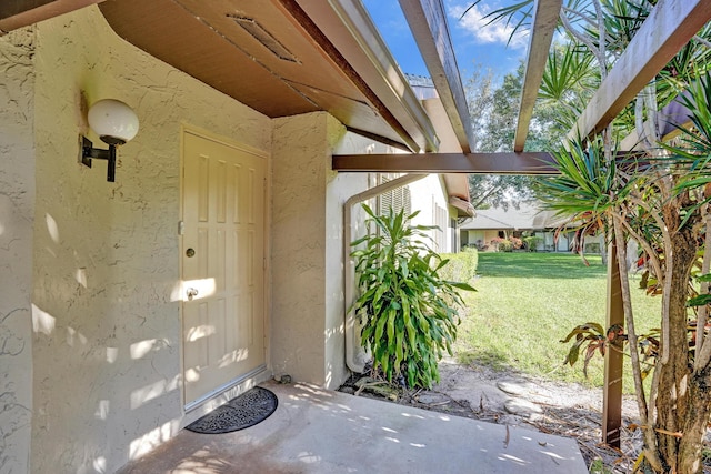 entrance to property with a lawn