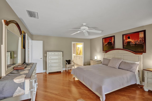 bedroom with ensuite bathroom, ceiling fan, and light hardwood / wood-style flooring