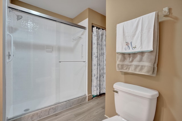 bathroom featuring toilet, walk in shower, and hardwood / wood-style floors