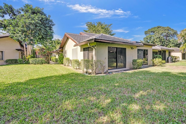 rear view of property featuring a lawn