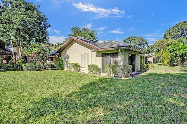 view of home's exterior with a yard and solar panels