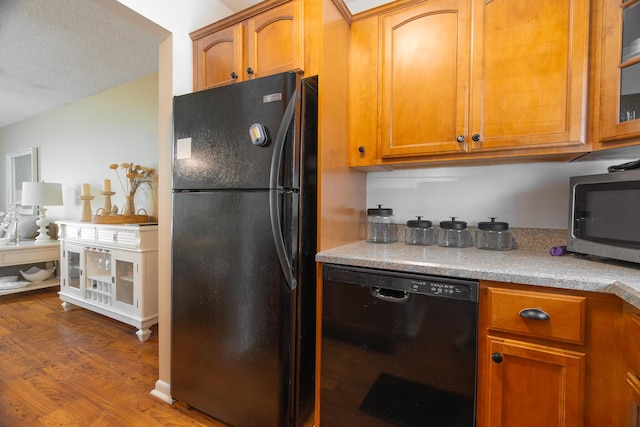 kitchen featuring dark hardwood / wood-style flooring and black appliances