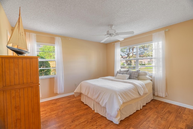 bedroom featuring a textured ceiling, hardwood / wood-style flooring, and ceiling fan