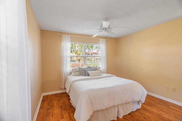 bedroom featuring ceiling fan, a textured ceiling, and hardwood / wood-style flooring