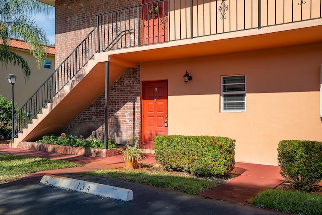 view of exterior entry featuring stucco siding and brick siding