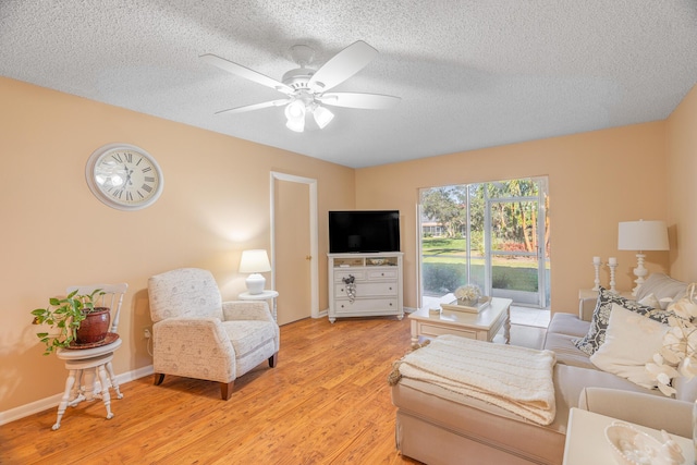 living room featuring a textured ceiling, light hardwood / wood-style flooring, and ceiling fan