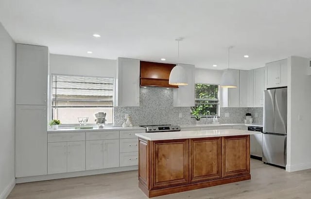 kitchen with hanging light fixtures, white cabinetry, a center island, and stainless steel appliances