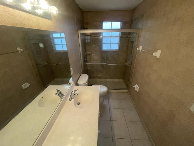 bathroom featuring tile patterned flooring, vanity, toilet, and an enclosed shower