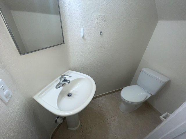 bathroom featuring tile patterned flooring, toilet, and sink