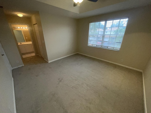 carpeted spare room featuring ceiling fan