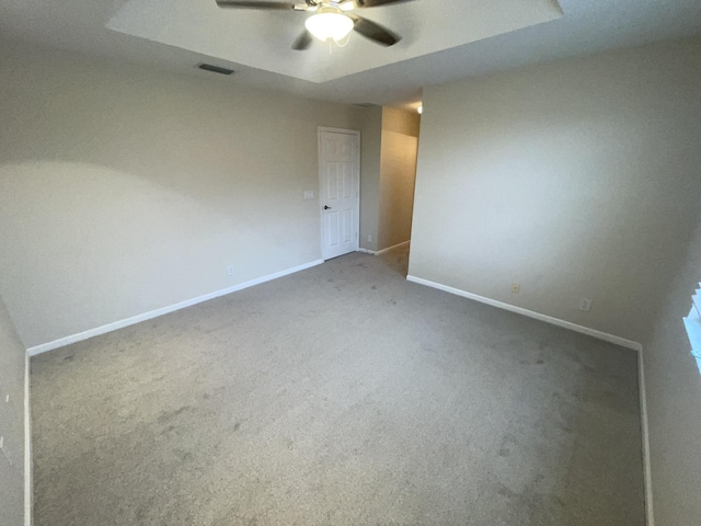 unfurnished room featuring carpet flooring, ceiling fan, and a tray ceiling