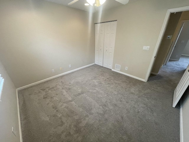 unfurnished bedroom with ceiling fan, a closet, and dark colored carpet